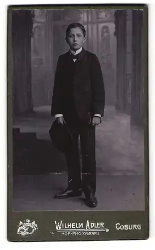 Fotografie Wilhelm Adler, Coburg, Portrait kleiner Junge im Anzug mit Fliege und Hut