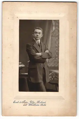 Fotografie Esch & Stein, Mülheim-Ruhr, Portrait junger Herr im Anzug mit verschränkten Armen
