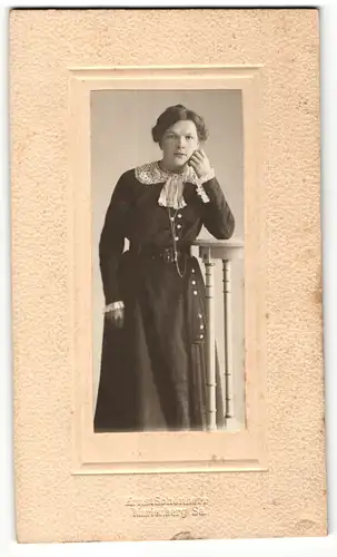 Fotografie Ernst Schönherr, Marienberg / Sa., Portrait junge Dame im modischen Kleid an Tisch gelehnt