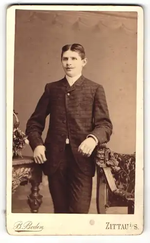 Fotografie B. Boden, Zittau i / S., Portrait junger Herr in modischer Kleidung an Stuhl gelehnt