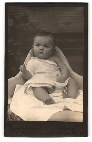 Fotografie Curt Meyer, Berlin-NO, Portrait sitzendes Baby im weissen Hemd mit nackigen Füssen