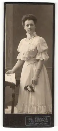 Fotografie Ed. Franke, Neustadt a / O., Portrait junge Dame im hübschen Kleid mit Zeitung und Blume