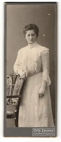 Fotografie Otto Zeumer, Crimmitschau, Portrait junge Dame im weissen Kleid an Stuhl gelehnt