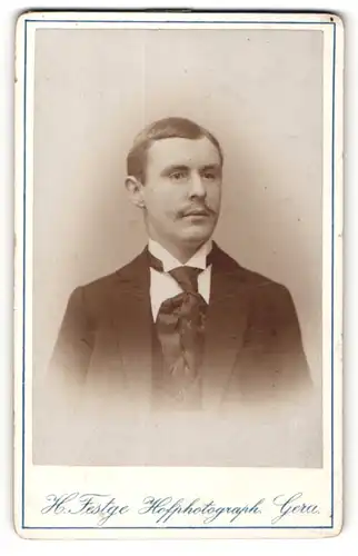 Fotografie Heinrich Festge, Gera, Portrait junger Herr im Anzug mit Krawatte und Schnurrbart