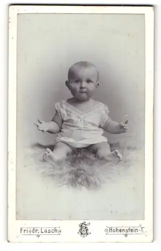 Fotografie Friedr. Lasch, Hohenstein-E., Portrait niedliches Baby auf einem Fell posierend