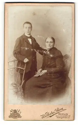 Fotografie Wilhelm Stein, Berlin, Portrait junger Mann steht neben seiner Mutter