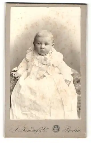 Fotografie A. Jandorf & Co., Berlin, Portrait eines kleinen Kindes im weissen Kleid auf einem Stuhl sitzend