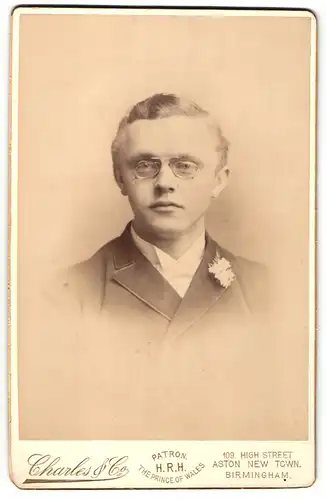 Fotografie Charles & Co., Birmingham, Portrait junger Herr im Anzug mit Fliege und Zwicker