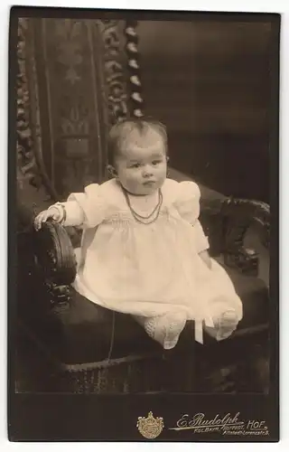 Fotografie E. Rudolph, Hof, Portrait eines Kleinkindes auf einem Stuhl sitzend