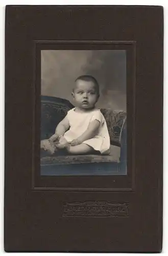 Fotografie Alfred Richter, Radebeul, Portrait sitzendes Baby im weissen Hemd mit Stofftier