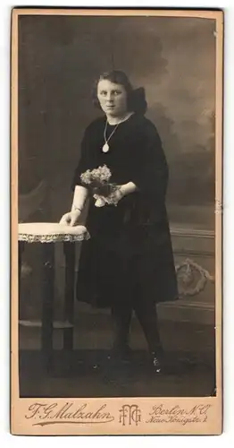 Fotografie F.G. Malzahn, Berlin, Portrait Mädchen im schwarzen Kleid mit Blumen