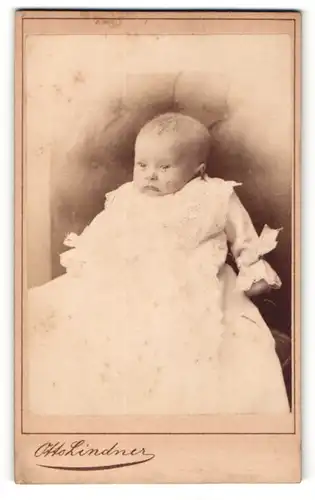 Fotografie Otto Lindner, Eberswalde, Portrait niedliches Baby im Taufkleid