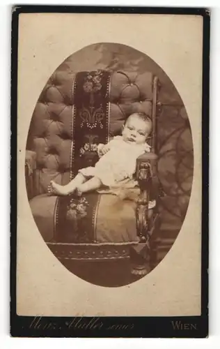 Fotografie Moritz Müller, Wien, Portrait bezauberndes Baby im Sessel liegend