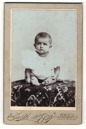 Fotografie Josef Justh, Wien, Portrait süsses Kleinkind mit Halskette im weissen Hemdchen