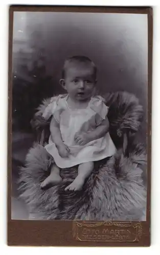 Fotografie Otto Martin, Dresden-Löbtau, Säugling in weissem Kleidchen auf einem Fell