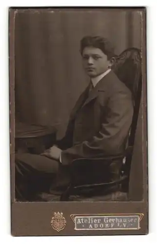 Fotografie Wilhelm Gerhauser, Adorf i / V., Portrait junger Mann im Anzug am Tisch sitzend