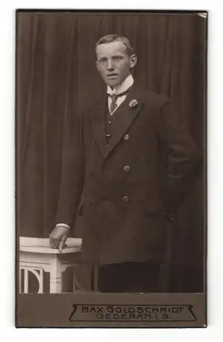 Fotografie Max Goldschmidt, Oederan i. S., Portrait junger Herr im Anzug mit Krawatte und Ansteckblume