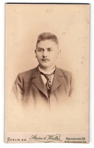 Fotografie Strom & Walter, Berlin, Portrait elegant gekleideter junger Mann mit karierter Krawatte