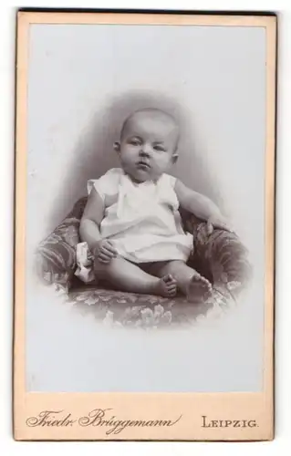 Fotografie Friedr. Brüggemann, Leipzig, Portrait pausbäckiges Baby im Hemdchen