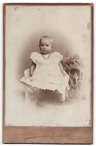 Fotografie D. Wettern, Hamburg, Portrait niedliches Kleinkind im weissen Kleid mit Halskette