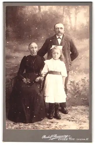 Fotografie Rudolf Brenning, Osten a. Oste, Langestr. 36, Strenge Grosseltern neben süssem Kind in Kleid und Haarschleife