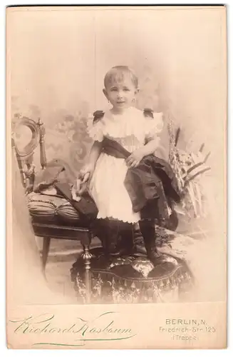Fotografie Richard Kasbaum, Berlin, Friedrich-Str. 125, Süsses kleines Mädchen im Kleid mit Spielzeug in der Hand