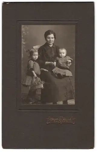 Fotografie Heinrich Wolle, Sulingen, Portrait bürgerliche Dame mit Kleinkind auf dem Schoss und Tochter