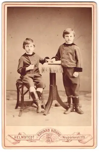 Fotografie Eduard Kühne, Helmstedt, Neumärkerstrasse 279, Portrait zwei modisch gekleidete Jungen mit Buch am Tisch