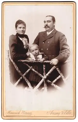 Fotografie Heinrich Werner, Aussig a. d. Elbe, Teplitzerstrasse 15, Portrait bürgerliches Paar mit Kleinkind am Zaun