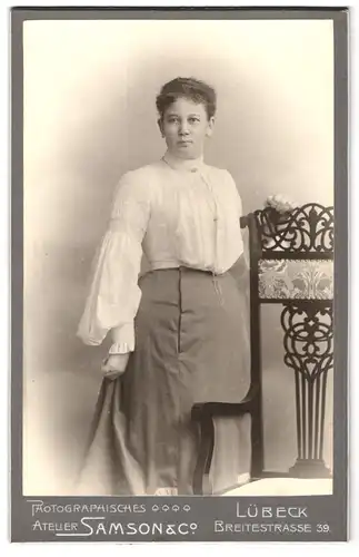 Fotografie Samson & Co., Lübeck, Breitestrasse 39, Portrait junge Dame in weisser Bluse an Stuhl gelehnt