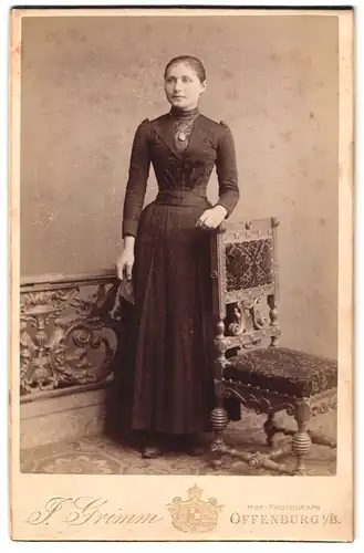 Fotografie Julius Grimm, Offenburg i / B., Portrait bürgerliche Dame mit Buch an Stuhl gelehnt