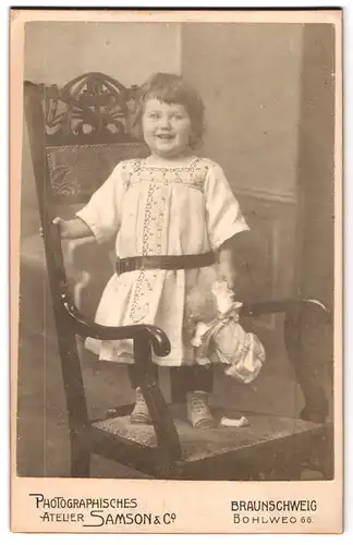 Fotografie Samson & co., Braunschweig, Bohlweg 66, Portrait kleines Mädchen im hübschen Kleid mit Puppe