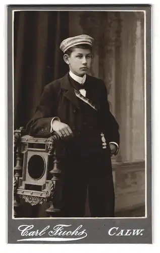 Fotografie Carl Fuchs, Calw, Marktplatz 42, Portrait Student Fritz im Anzug mit Couleur und Orden, Mütze