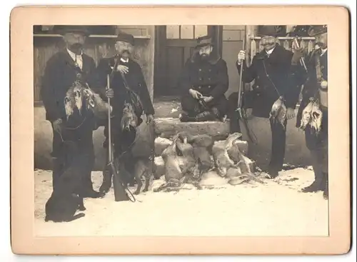 Fotografie unbekannter Fotograf und Ort, Jäger mit Jagdbeute und Jagdhund, Hasen, Flinte