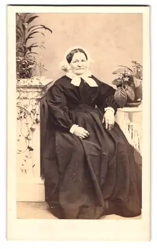 Fotografie Theodor Schlüter, Pinneberg, Ältere Frau in schwarzem Kleid trägt weisses Kopftuch