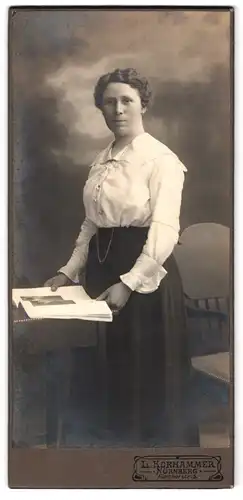Fotografie L. Korhammer, Nürnberg, Fürtherstrasse 5, Portrait bürgerliche Dame mit Zeitung an Tisch gelehnt