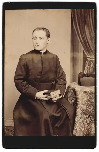 Fotografie unbekannter Fotograf und Ort, Portrait Geistlicher im Talar mit Birett und Bibel