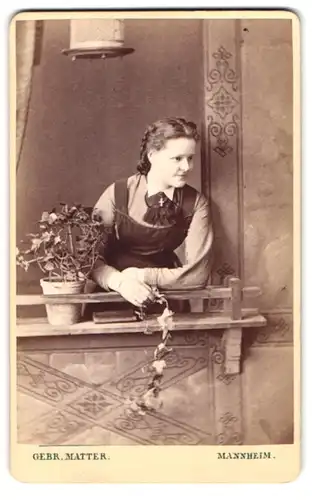 Fotografie Gebr. Matter, Mannheim, Heidelbergerstr., Portrait junge Frau am Fenster stehend, Studiokulisse
