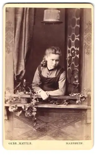 Fotografie Gebr. Matter, Mannheim, Heidelbergerstr., Portrait Frau im Kleid schaut verträumt aus Fensterbrüstung