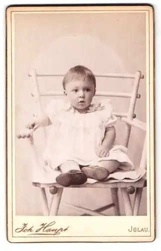 Fotografie Joh. Haupt, Iglau, Tiefegasse 11, Portrait kleines Mädchen im weissen Kleid auf Stuhl sitzend