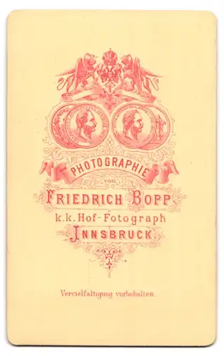 Fotografie Friedrich Bopp, Innsbruck, Portrait elegant gekleidetes Paar an Sockel gelehnt