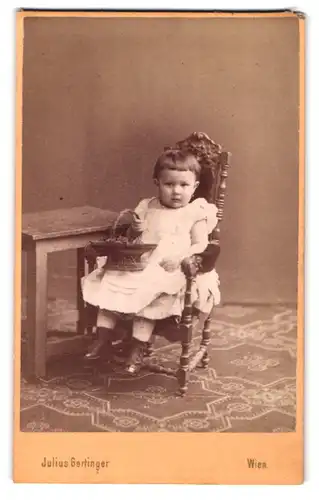 Fotografie Julius Gertinger, Wien, Margarethenstrasse 19, Portrait hübsch gekleidetes Mädchen mit Korb auf Stuhl sitzend