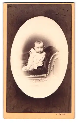 Fotografie L. Bauer, Wien, Mölkerbastei 20, Portrait niedliches Baby im weissen Hemd mit nackigen Füssen