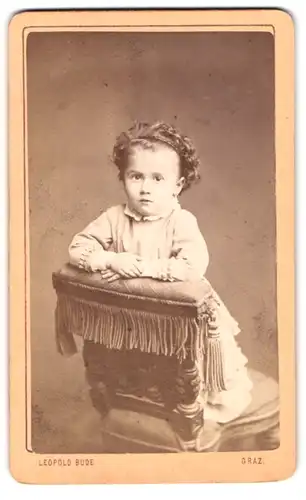Fotografie Leopold Bude, Graz, Salzamtgasse 3, Portrait kleines Mädchen im hübschen Kleid auf Stuhl stehend
