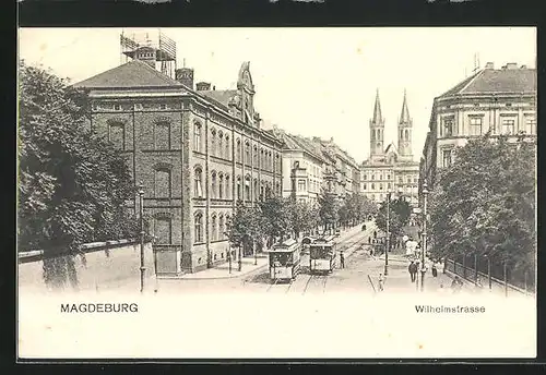 AK Magdeburg, Wilhelmstrasse mit Gebäuden, Kirchtürmen und Strassenbahn