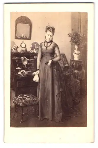 Fotografie Goupil & Cie., Paris, Rue Capital 9, Portrait junge Frau im Gründerzeitkleid vor Schreibsekretär posierend