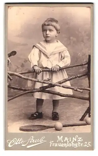Fotografie Otto Strub, Mainz, Frauenlobstrasse, Portrait kleines Mädchen im Matrosenkleid an Zaun gelehnt