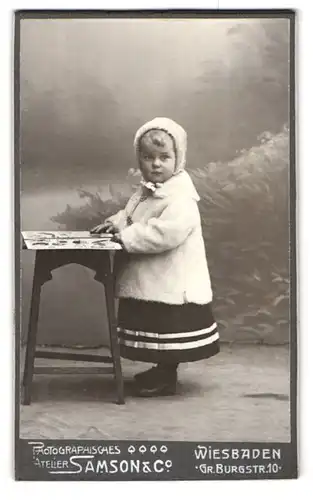 Fotografie Samson & Co., Wiesbaden, Gr. Burgstrasse 10, Portrait kleines Mädchen in hübscher Kleidung mit Bilderbuch