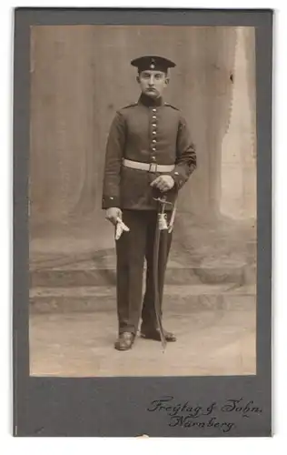 Fotografie Freytag & John, Nürnberg, Rosenaustr. 6, Portrait junger Soldat in Uniform mit Säbel und Krätzchen, Portepee