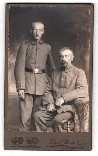 Fotografie Carl Bestel, Minden i. W., Portrait Soldaten in Feldgrau Uniform im Atelier
